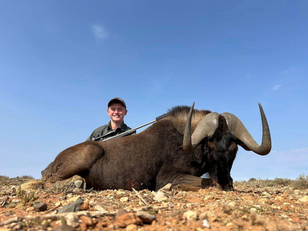 Hunter posing with black wildebeest trophy.