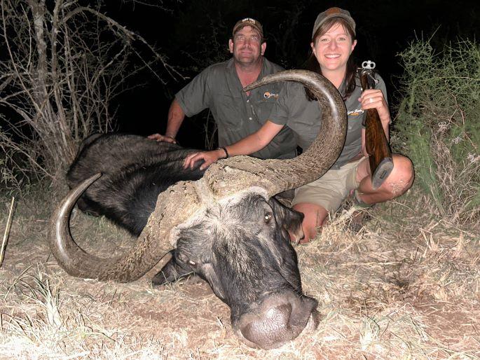 two people posing with a Cape buffalo trophy