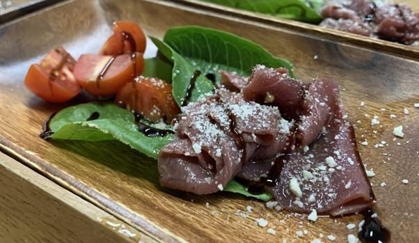 Carpaccio; springbuck meat thinly sliced and served raw, often with fresh herbs including rocket and parmesan cheese