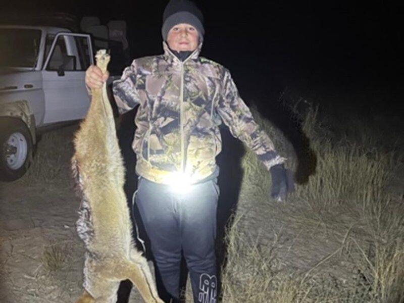 Boy showcasing the jackal he shot