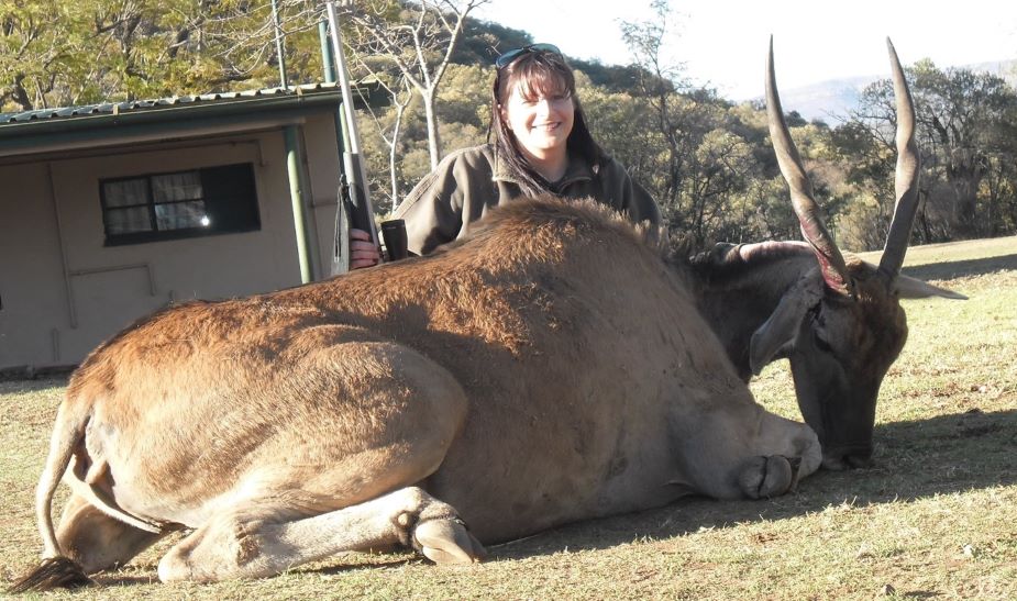 female posing with female cow she shot