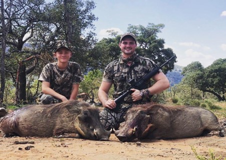 Two men with a warthog